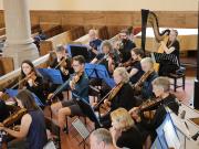 The orchestra with harpist Ellie Hetherington